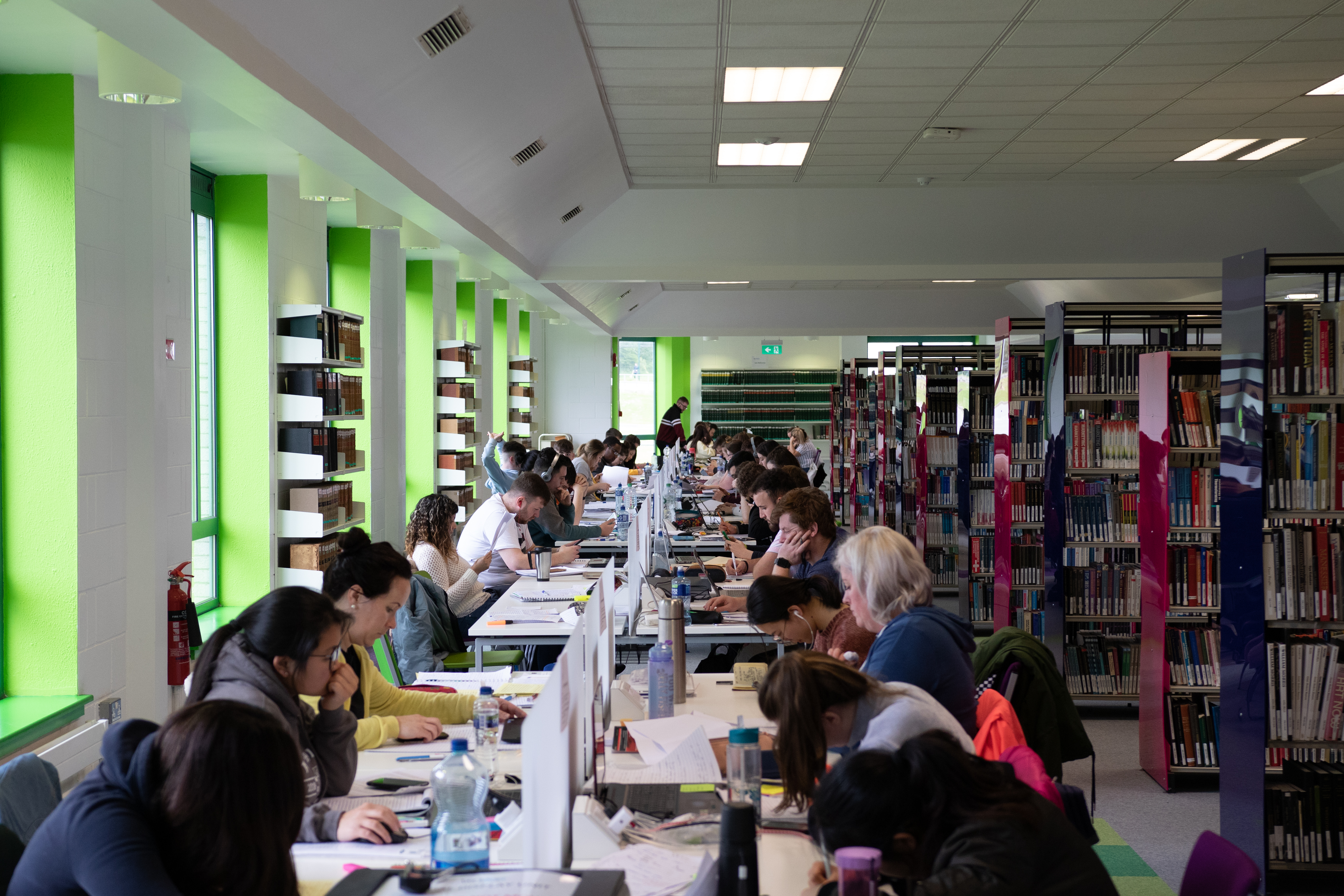 long row of study desks with students studying